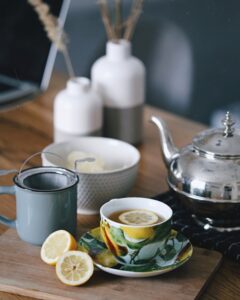 Verein PriseMUT - gray teapot beside mug filled with tea and lemon on top of table